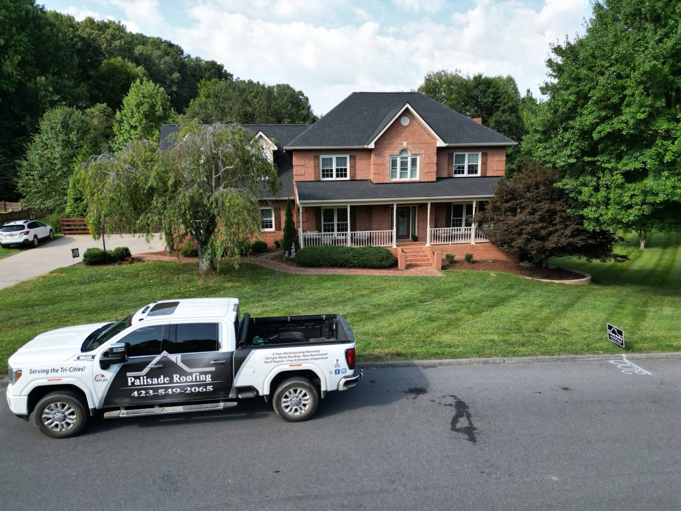 A Palisade Roofing truck in front of a Tri-Cities home with a newly installed roof